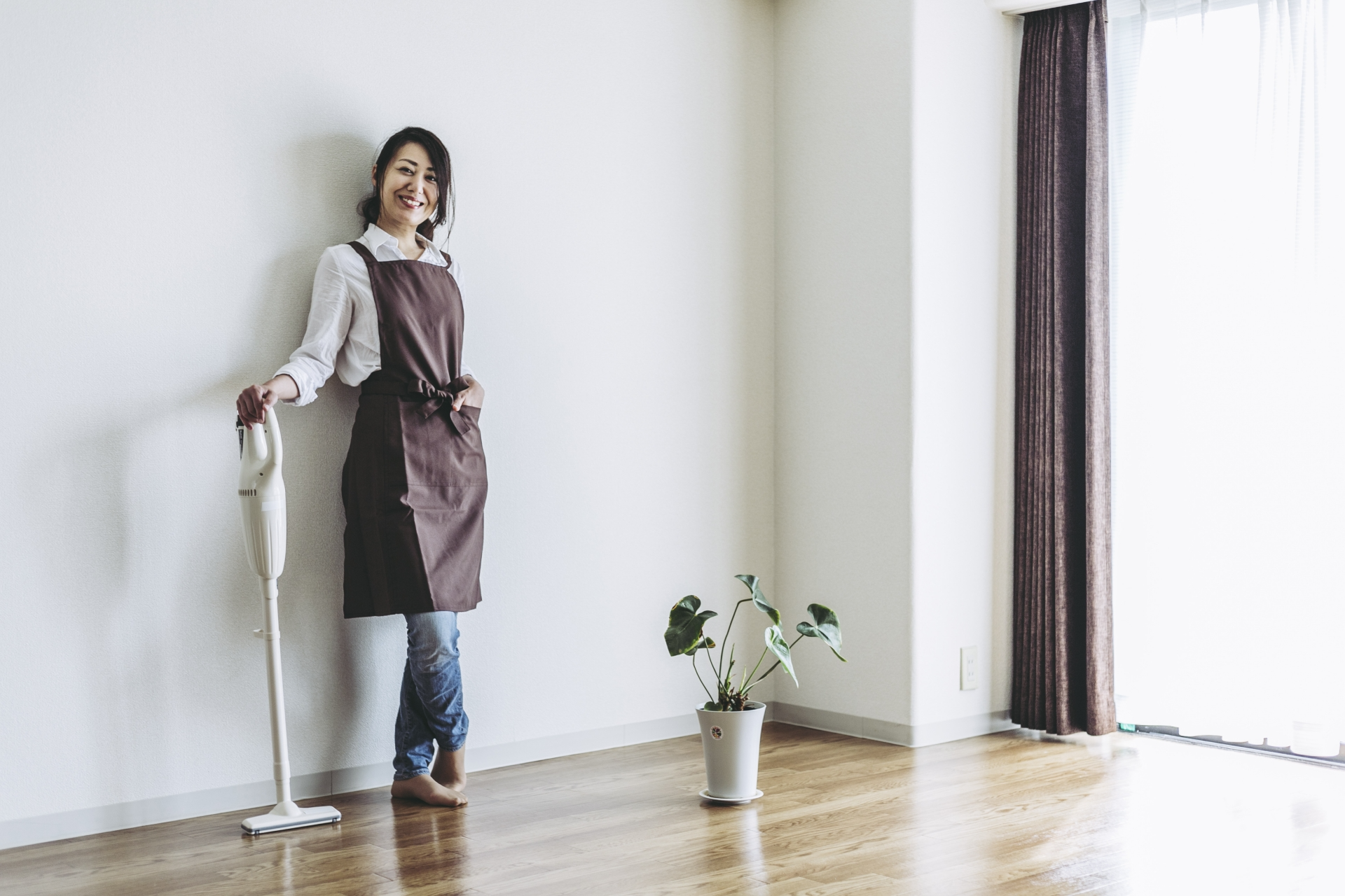 掃除機を片手に立つ女性